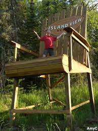 Large wooden deck chair on the side of a road has a seat large enough to accommodate several people, but no easy way to get up to it. Orr Mn Big Wooden Chair Gone