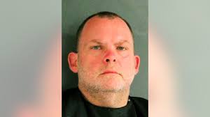 Man charged with keeping mother's body tarped in front yard