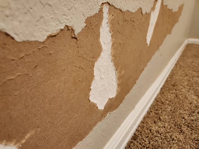 Damaged wall affecting drywall repair cost in Surrey before fixing