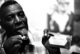 It's 1968 in San Francisco. Blues legend Howlin' Wolf is in a hotel room  lighting his pipe. He's holding a package of Edgeworth Tobacco. (Photo by Sandy  Guy Schoenfeld)