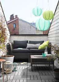 A Small Balcony With A Black Two Seat Sofa With Cushions And A Coffee Table Sofa 275 Small Balcony Furniture Balcony Furniture Balcony Decor