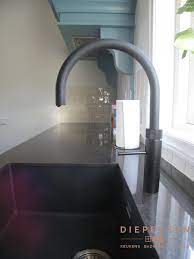 de zwarte quooker kraan past helemaal thuis in deze prachtige landelijke keuken benieuwd naar meer foto s bekijk de keuken ontwerpen keukens moderne keukens