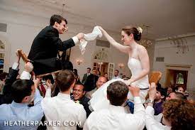 After The Ceremony The Party Here The Couple Dance Hoisted On Chairs Held By Friends And Share A Handkerchief Fo Global Wedding Travel Theme Wedding Wedding