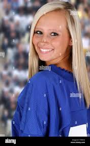 Teenage girl at a football game cheering for her team Stock Photo