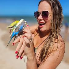 Uma Índia de Porto Seguro vive agora na Praia do Francês em Alagoas e ela  tem esses passarinhos lindos de estimação! Leva eles para a praia e deixa  tirar fotos com eles