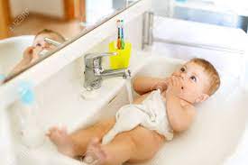 Cute baby taking bath in kitchen sink. Cute Adorable Baby Taking Bath In Washing Sink And Grab Water Stock Photo Picture And Royalty Free Image Image 97321880