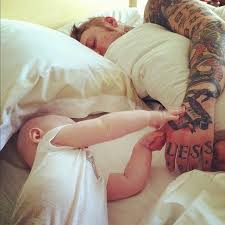 The baby is held down as the 'tattoo artist' appears to etch a design on the tot's chest. Tattooed Men Holding Babies Parent Tattoos Dad Tattoos Men With Babies