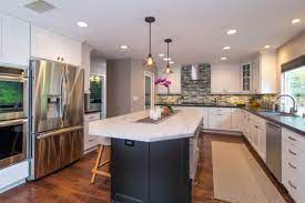 Large kitchen remodeling with white furniture and dark flooring. Kitchen Island Design Ideas Remodel Works