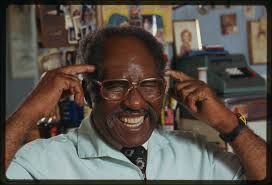 Barber Louis McDowell poses for photos in his barber shop.