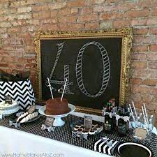 Birthday cake on a table against a wall with decoration flags and balloons. 40th Birthday Party Idea For A Man 40th Birthday Parties 40th Birthday Men 40th Birthday Decorations