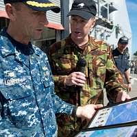 New Zealand Army Lt. Col. Ben Pitt, commander of land forces, gives a gift  to Capt. Wallace Lovely, Pacific Partnership 2013 mission commander.