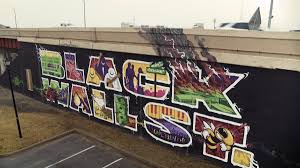 A pedestrian stands in front of the black wall street mural in the. The Mass Graves Of Tulsa Vox