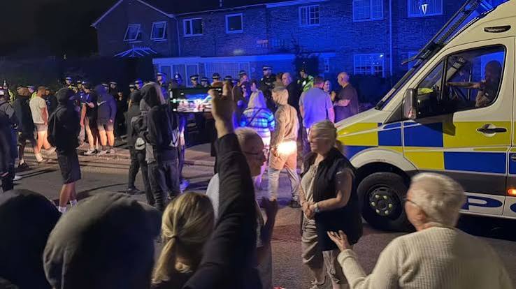 Police escort men from home after anti-migrant mob stormed properties