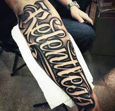 Mens Relentless Script Tattoo On Outer Forearm With Neagtive Space Tattoo Lettering Styles Tattoo Script Tattoo Lettering