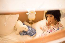 Asian Kid Sucking Thumb And Looking Ponder In Bed With Dolls Stock Photo,  Picture and Royalty Free Image. Image 96491089.