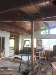 Like installing 2 new support posts (minimum) with new beam, out from the existing beam to provide the needed headroom. Removing Or Replacing A Post Supporting A Bolted Joint In A Long Glue Lam Beam Home Improvement Stack Exchange
