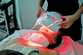 close up of woman covering eyes during LED light therapy session