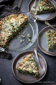 Low Carb Spinach And Bacon Crustless Quiche In A Clear Pie Plate With Slices On Dark Gray Ceramic Plates W Quiche Recipes Spinach Quiche Recipes Keto Meal Prep