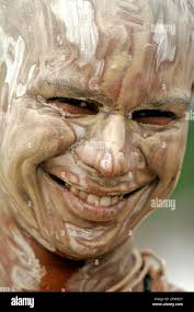 A Brahmin boy with his face smeared with ash smiles as he performs rituals 