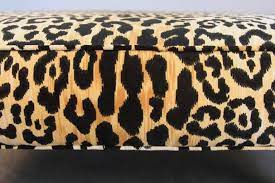 This upholstered ottoman features a bold, leopard print on a cotton/linen blend and a small welt edge. Leopard Print Ottoman Or Coffee Table For Sale At 1stdibs