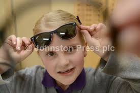 30525640-Browns Optician Bonnyrigg practice manager Andrew Lamont presents  Grace McLean 7 with her designer sunglasses after winning their Easter  drawing competition.
