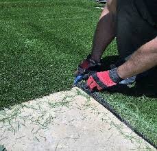 Gray stone pavers with grass or artificial grass. Installing Artificial Grass Between Pavers Sgw