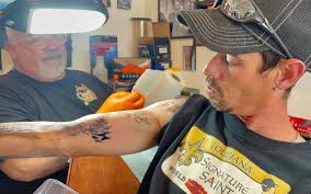 Devoted Who Dat reaches 100 Saints autograph tattoos