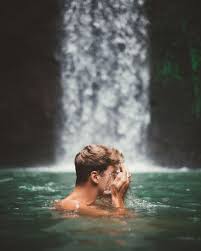 Side View Of Man Washing Face While Swimming In Clear Water Of Lake With Waterfall On Background Ba Pool Photography Waterfall Photography Lake Photoshoot