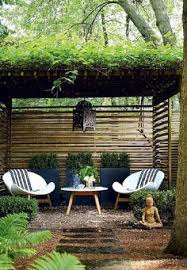 Zen Garden Features A Pergola Over A Pair Of White Modern Chairs And Outdoor Accent Table Placed Before Three Black P Zen Garden Design Backyard Backyard Patio