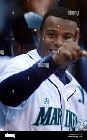 Seattle Mariners' Ken Griffey Jr. jokes with fans from the dugout during a  baseball game against the Texas Rangers in Seattle