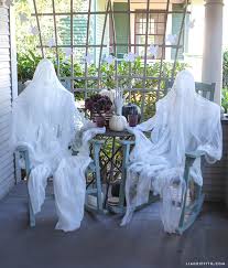 Gauze is draped on the frame of a diy halloween ghost for a spooky front yard decoration. Foam Head Form Muslin Ghost Lia Griffith
