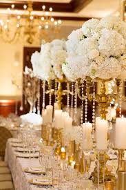 A perfect modern detail to add to your wedding décor, this tall gold geometric centerpiece or candle holder is totally on trend. Gold Candelabra Centerpiece With White Roses