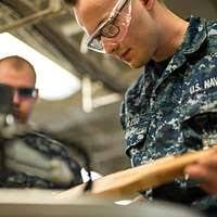 Hospital Corpsman 2nd Class Cody Chandler, assigned to U.S. Naval Hospital  (USNH) Yokosuka's Multi-Service Unit, greets Master Chief Petty Officer of  the Navy Steven S. Giordano during a tour of the hospital's