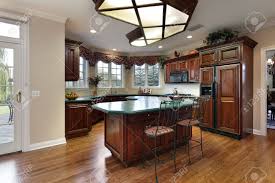 Agree or disagree, i love seeing this neutral cabinetry trend, from all gray kitchens to gray and white kitchens.it's a combination that can be modern or farmhouse (or modern farmhouse) or more classic or contemporary depending on the style of cabinetry, hardware choice, and shade of gray. Kitchen With Dark Wood Cabinets And Green Island Counter Stock Photo Picture And Royalty Free Image Image 10083643