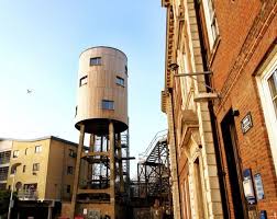 The converted water tower seen standing just behind the master's house (right). Citylab Bloomberg Water Tower House Water Tower Tower