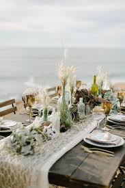 Decorative Fish Netting Over Neutral Table Runner And Beachy Bottles Beach Wedding Tables Bohemian Wedding Decorations Beach Table