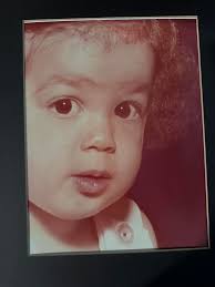 This a photo of me and my first born who died of SIDS. It is the only photo  I have of me holding her. Can someone fix this picture? My hair was