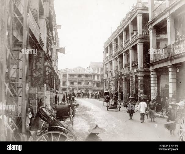 Vintage 19th century photograph: Hong Kong (China) c.1880's - shops in the Chinese quarter of the city. Raod busy with traffic, pedestrians and rickshaws Stock Photo - Alamy