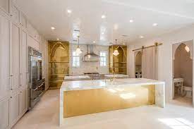 In this small apartment of 37 sqm, the designer solved the kitchen question in an original and stylish way. Gold Leaf Kitchen Island With Marble Waterfall Countertop Mediterranean Kitchen