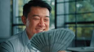 Wealthy asiana korean man successful rich businessman banker investor hold  money banknotes dollar currency win in lottery cash salary bonus success  profitable investment at stock exchange bank deposit