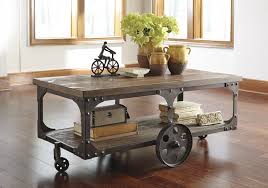 From Ashley S Rustic Accents Collection This Rustic Wheel Cocktail Table Is Inspired By A Factory Cart Cart Coffee Table Brown Cocktail Table Ashley Furniture