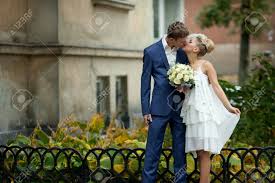 A deep blue wedding dress is perfect for creating a moody, dramatic bridal look (gothic wedding, perhaps?). Groom In Blue Suit Kisses A Bride In Short White Dress Stock Photo Picture And Royalty Free Image Image 71778442