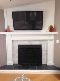 Most often black color is used to create a black slate fireplace hearth which is found in most homes. Fireplace With Black Slate Hearth And Marble Subway Tiles Wood Paneling Behind Mounted Tv Slate Fireplace Home Fireplace Living Room With Fireplace