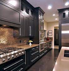 This minimal kitchen has a very cooling effect created from very sleek and modern black kitchen cabinets in a dramatic dark brown, sleek appliances, and cool painted walls. 80 Beautiful Kitchen Backsplash Decor With Dark Cabinets Dream Kitchens Design Kitchen Design Kitchen Design Small