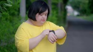 Asian girl with down syndrome look at the clock and rejoicewhile exercising  in the park