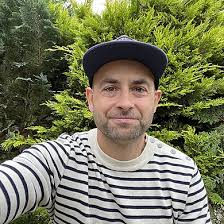 Logoet fra podcasten på armen gør Thomas stolt