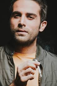 Homme en t-shirt gris portant une casquette noire photo