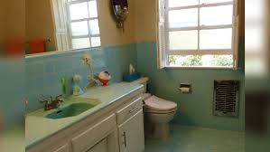 Mandy, whose nashville home was featured on a beautiful mess, took the black and white of her bathroom tiles and ran with it, adding a black and white striped shower curtain, bright white linens, and artwork to match. Bathroom Makeover Printed Wallpaper Makes Colorful Tile Look New