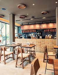Playful mosaic flooring, hanging ivy, sleek lighting fixtures and other cool elements make this space looks bold yet relaxing (via @lorrainemarie_design.decor) light wood partition and tables, light grey furniture and black for highlighting. The World S Best Coffee Shops For Design Lovers Cafe Interior Design Coffee Shop Interior Design Coffee Shop Design