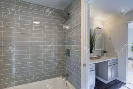 Bathroom flooring bathroom tile tile floors bathrooms flooring materials and supplies tile ceramic tile glass tile mosaic tile concrete marble stone. Warm And Clean Bathroom Boasts Grey Glass Tile Shower Surround Stock Photo Picture And Royalty Free Image Image 93400226